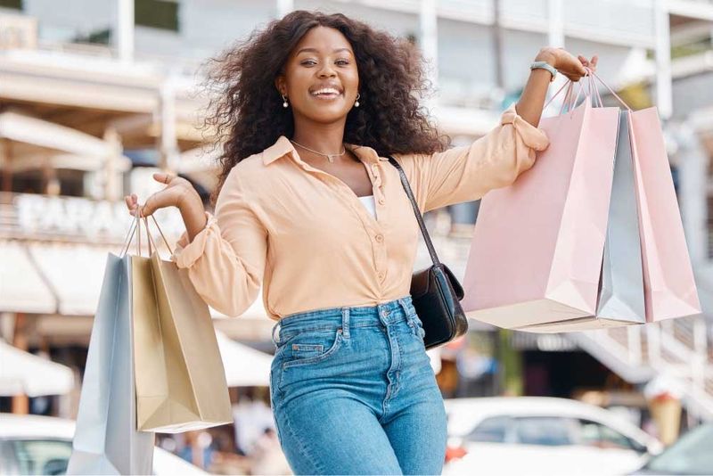 A lady holding shopping bags after over-spending on clothes and items